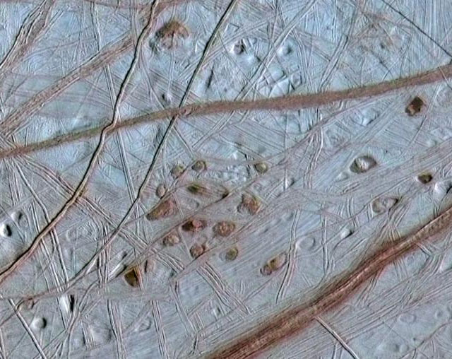 Спутник Юпитера Европа, в отличие от большинства тел Солнечной системы, довольно гладок и почти полностью лишен метеоритных кратеров. Его поверхность, состоящая из водяного льда, постоянно разглаживается, сохраняя из деталей рельефа лишь густую сеть неглубоких трещин. Подвижность коры Европы говорит о том, что под ней скрыт некий менее твердый материал, однако это может быть не толща воды, а всего лишь рыхлая влажная масса, похожая на подтаявший снег. Изображение получено при помощи Межпланетной станции Galileo (оно составлено из снимка с низким разрешением, сделанного 28 июля 1996 года во время первого облета Юпитера станцией «Галилео», и снимка с высоким разрешением, сделанного 31 мая 1998 года во время 15-го облета). © NASA/JPL/University of Arizona/University of Colorado; фото с сайта photojournal.jpl.nasa.gov